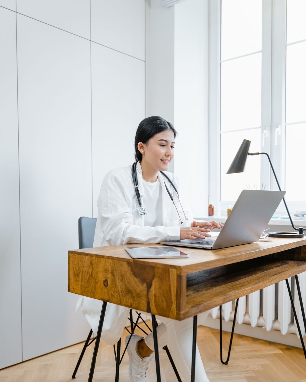 Nurse practitioner in white coat during a telemedicine consultation